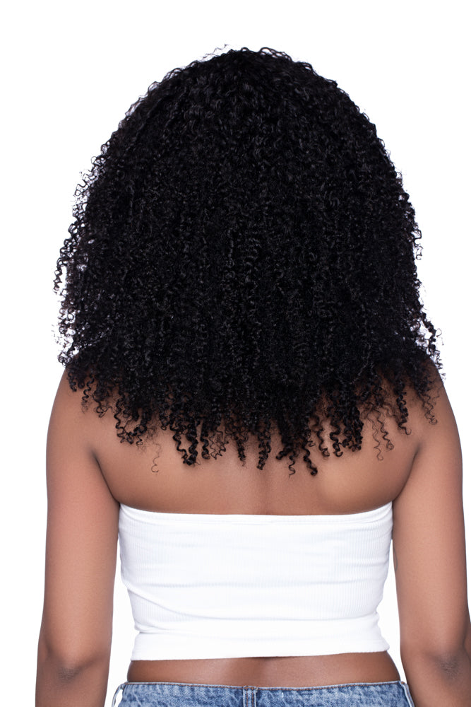 Woman facing away from the camera, wearing the ‘Kai’ Half Wig styled in voluminous kinky curls that reach her upper back. The texture blends seamlessly from crown to ends, showcasing natural movement and fullness.