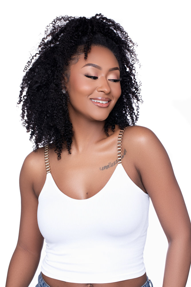 Woman with medium-length, defined kinky curls in a half wig installation. The texture mimics 3C/4A curls and gives a soft, fluffy finish perfect for casual or glam looks.