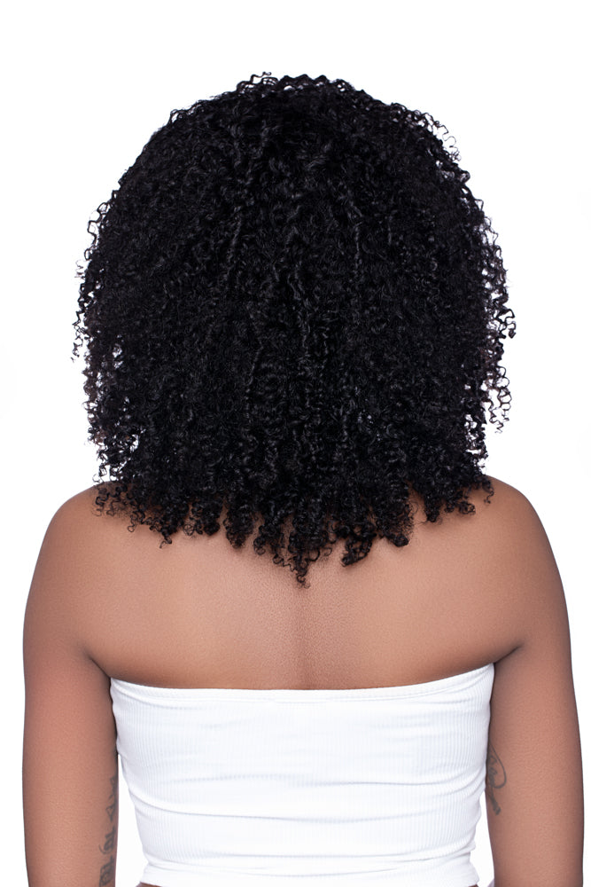 Back view of the Half Wig ‘Kai’ in kinky curly texture, showing defined curls cascading down the model’s back with natural volume and mid-length density.