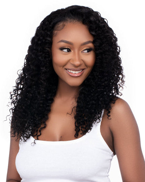 Woman with long, curly wig wearing a white top and blue jeans on a white background