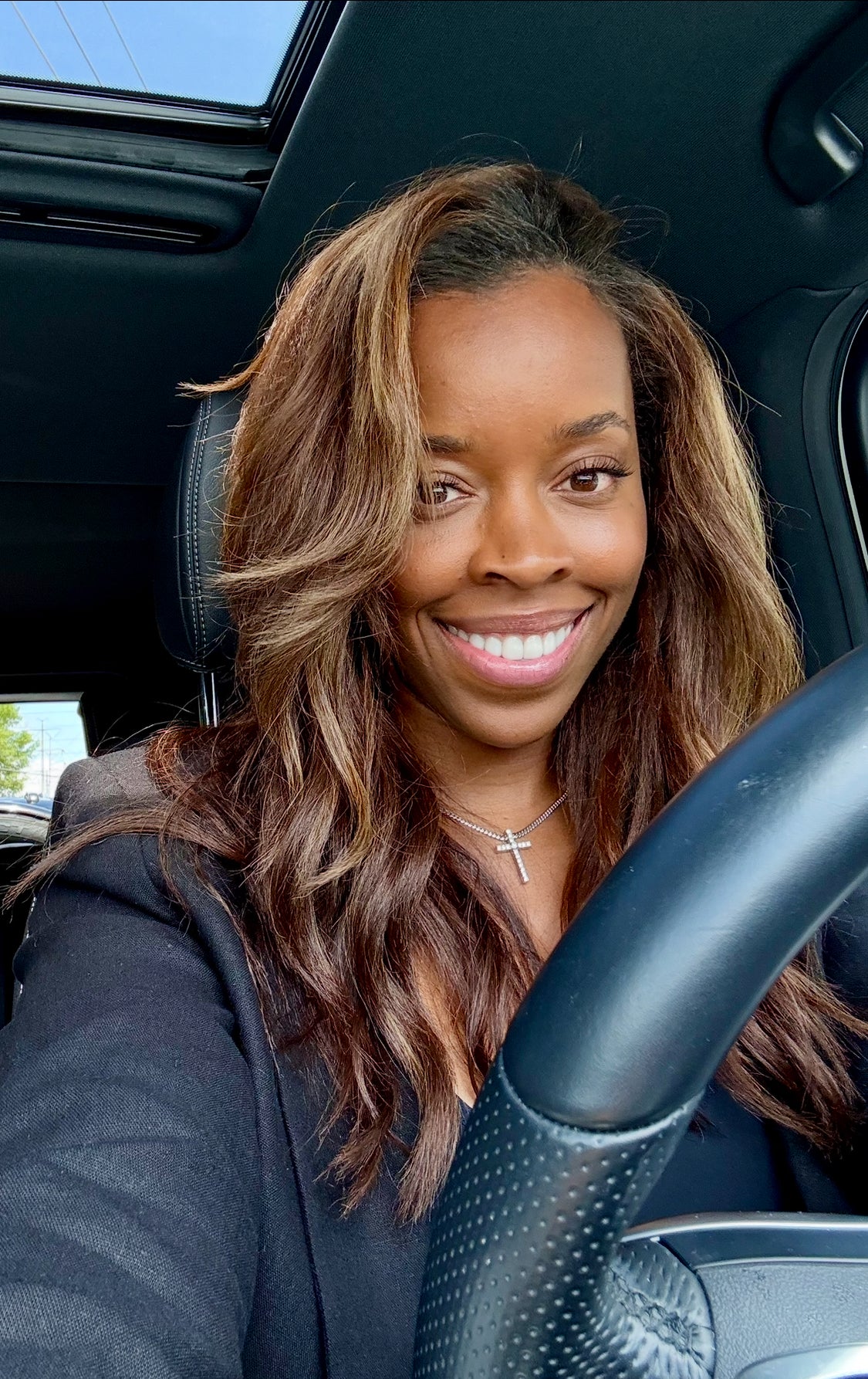 Woman sitting in a car smiling at the camera
