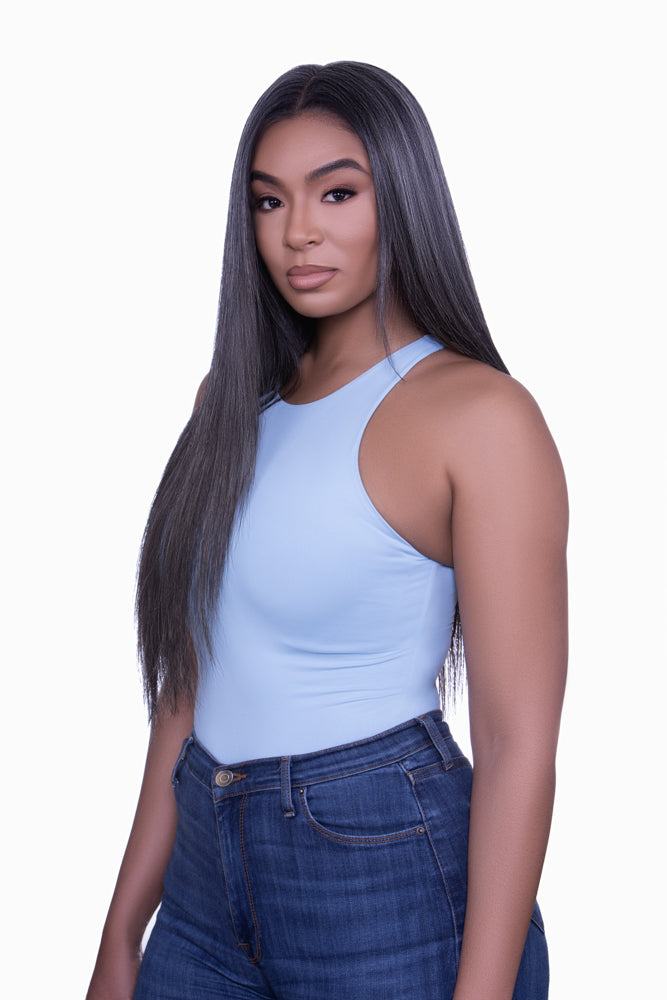 A woman with gray hair featuring clip-in hair extensions that are blends of dark brown and beige hues.