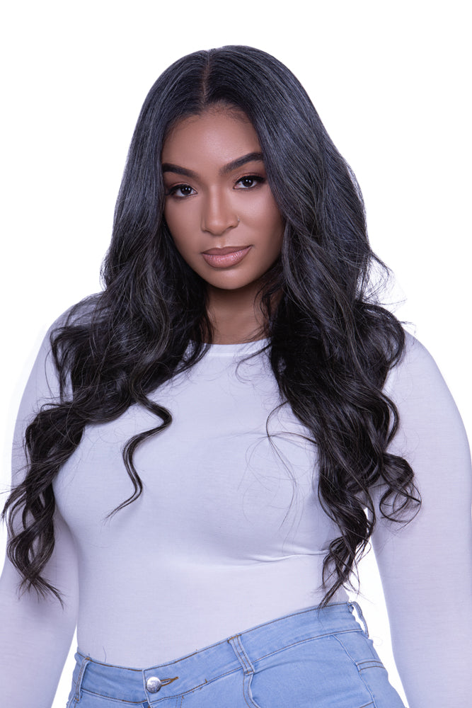 A woman with gray hair featuring clip-in hair extensions that are blends of dark brown and beige hues.