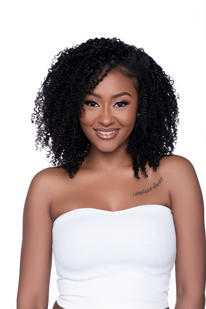 Close-up of a woman modeling the Half Wig ‘Kai’ in a rich, kinky curly texture. The hair has a natural sheen, mid-length density, and a realistic blend perfect for protective styling or enhancing natural curls.