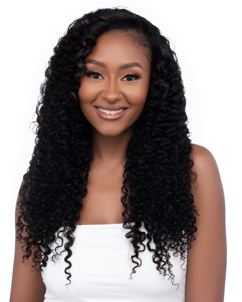 Woman with long, curly wig wearing a white top and blue jeans on a white background