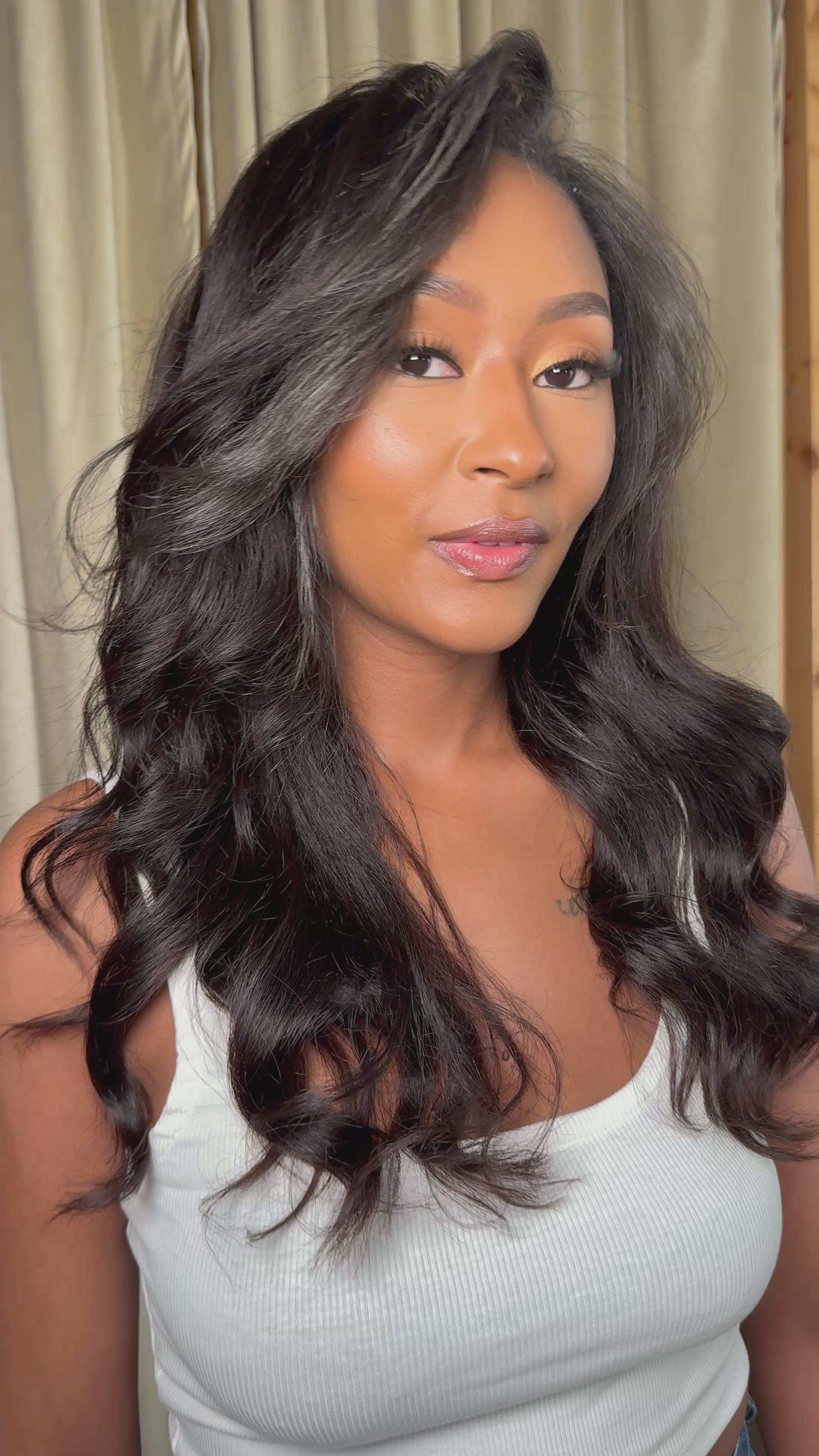 Model showing off the natural texture and length of the ‘Calli’ Kinky Straight Half Wig with soft glam makeup and a white top