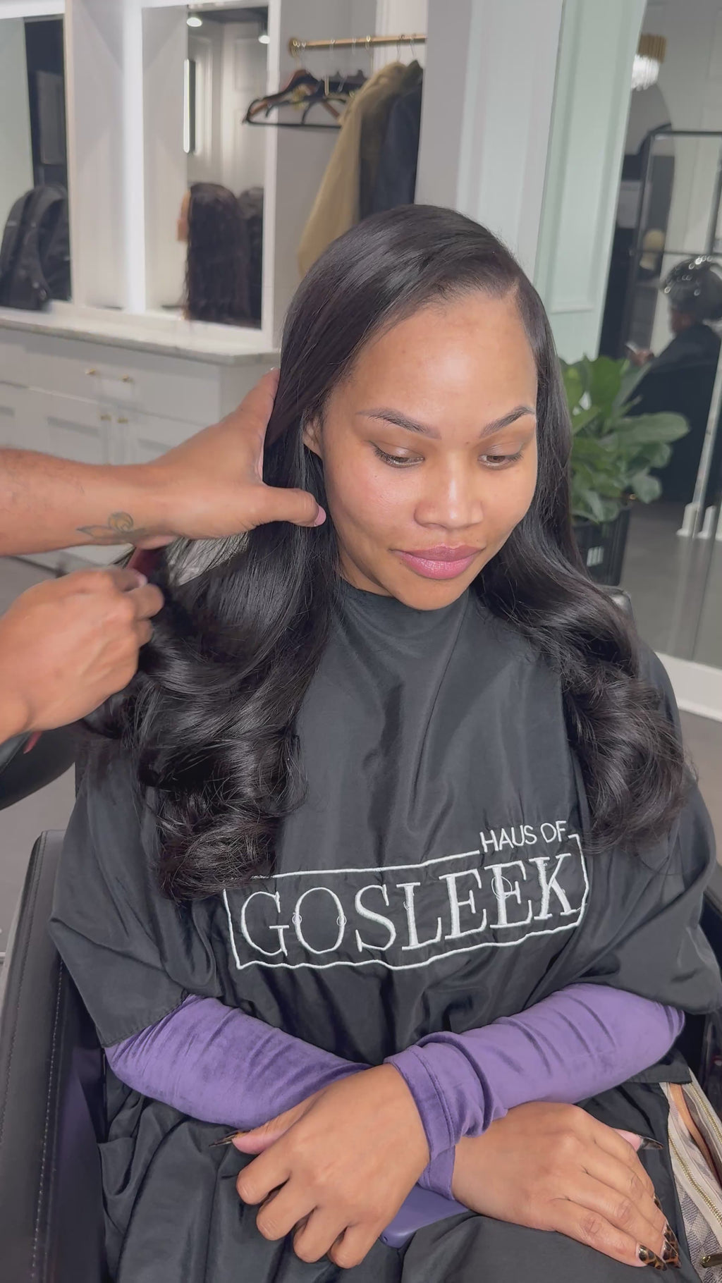 video of woman getting her hair done, wearing Go Sleek Burmese Body Wave bundle in natural black
