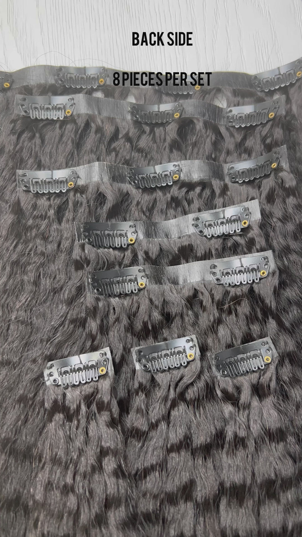 Top view flat lay of Go Sleek’s Seamless Kinky Straight Clip-Ins, showing 8 separate wefts with visible clips. Each piece features a natural kinky straight texture and seamless, flat bases designed for undetectable blending.