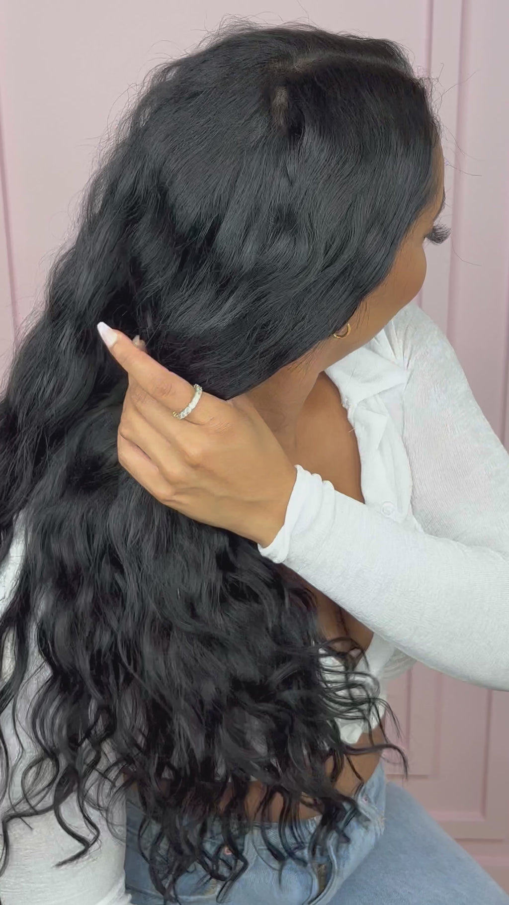 woman confidently playing with her Seamless Clip-Ins: “Venus” Body Wave. She is wearing white long sleeve crop top.