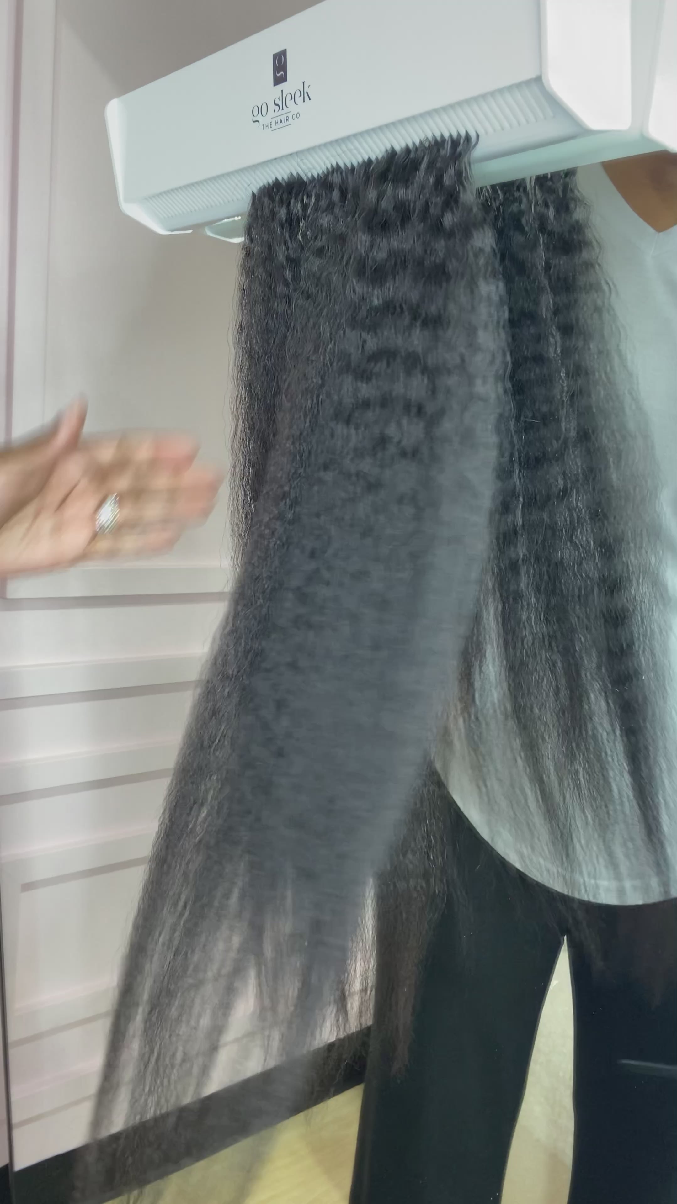 A woman effortlessly straightens a set of clip-in hair extensions using a flat iron. The hair glides smoothly through the straightener, showcasing the high quality and heat resistance of the extensions. The clip-ins blend seamlessly with her natural hair, highlighting their realistic texture and easy styling.