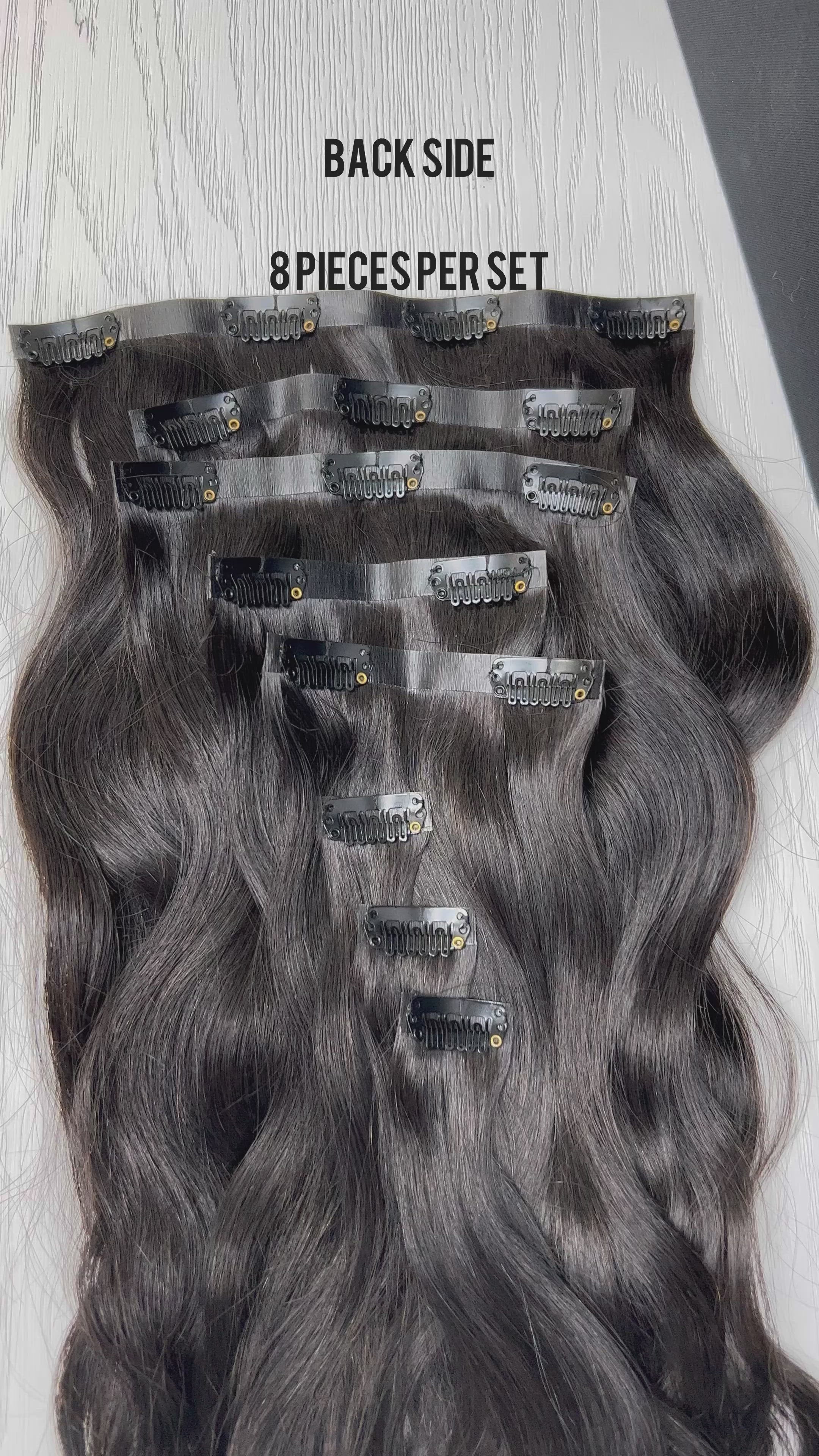 Top view flat lay of Go Sleek’s Seamless body wave Clip-Ins, showing 8 separate wefts with visible clips. Each piece features a natural kinky straight texture and seamless, flat bases designed for undetectable blending.