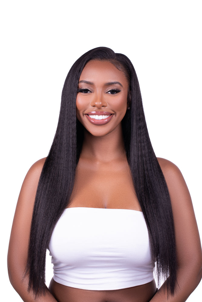 A woman with kinky straight black hair clip-ins wearing a white top