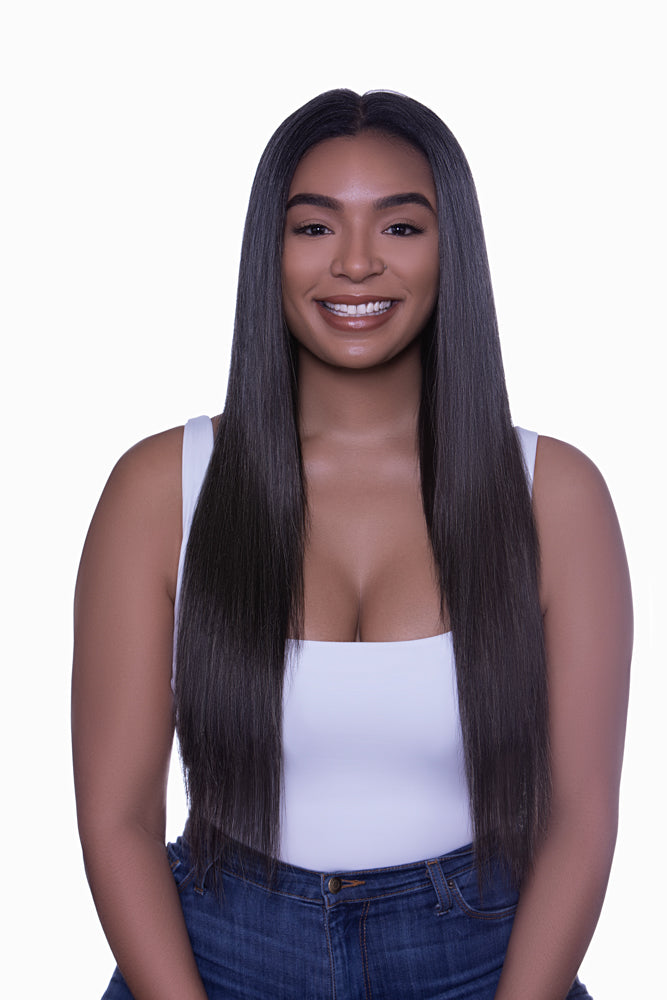 A woman with gray hair featuring clip-in hair extensions that are blends of dark brown and beige hues.