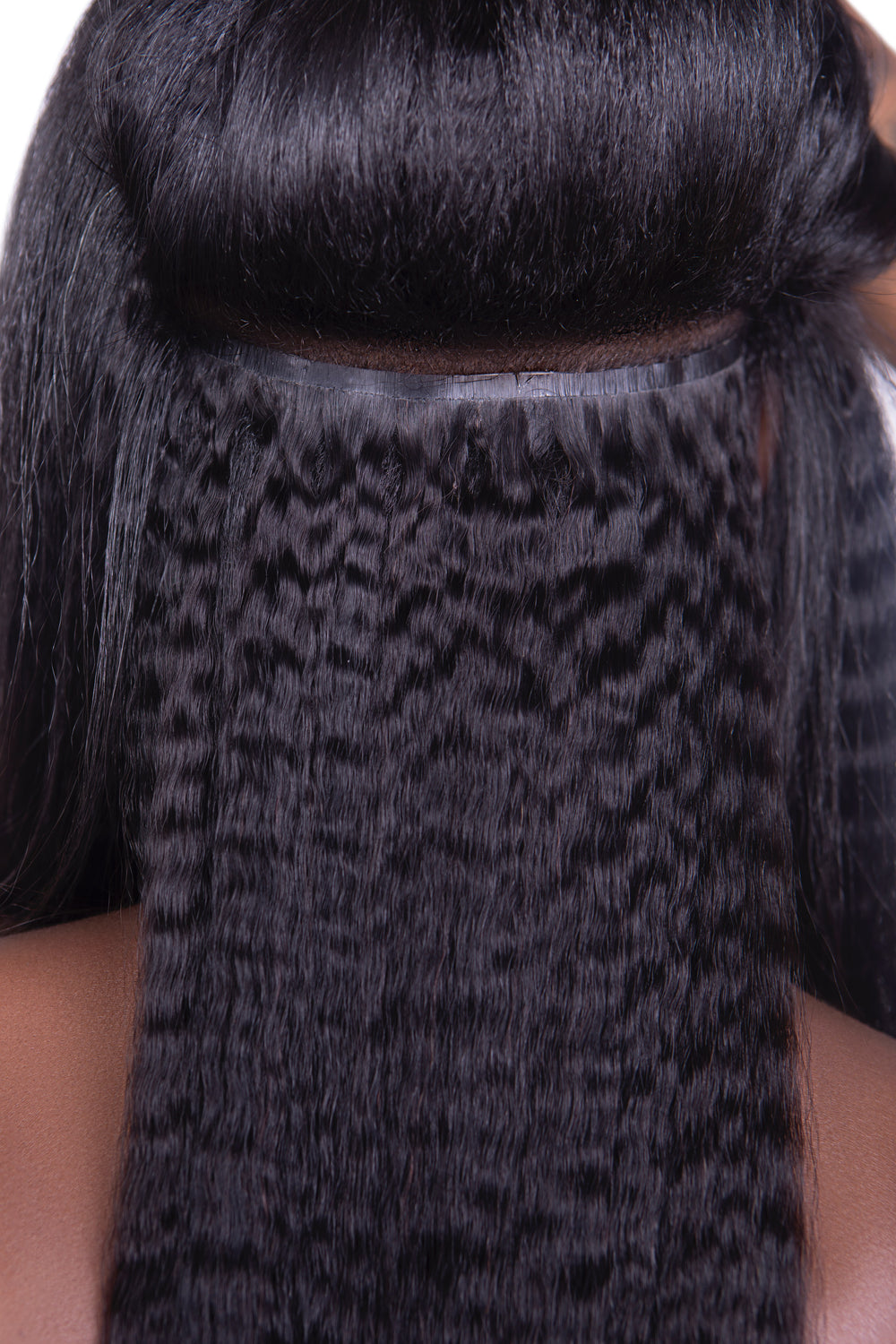 Close-up of Go Sleek Seamless Kinky Straight Clip-In Hair Extensions installed on model, showing natural texture blend with straightened leave-out and invisible weft track for a flawless finish.